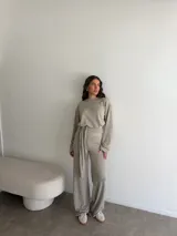 Conjunto de dos piezas de viscosa y poliéster color gris melange, compuesto por un buzo de manga larga y un pantalón largo de corte recto con lazo ajustable en la cintura.