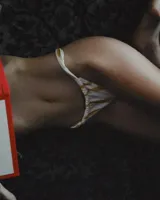 Bombacha de bikini confeccionada en lycra color blanco con rayas verticales color naranja.