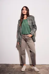 Blazer de corte recto con estampado de cuadros en tonos verdes y grises. Presenta solapas clásicas, cierre frontal y bolsillos laterales.