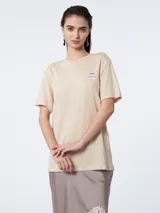 Remera color beige de lino con mangas cortas y logo estampado en el pecho.
