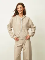Campera con capucha color beige, con cierre frontal plateado y bolsillos laterales.