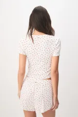 Pijama de viscosa y elastano de color blanco con estampado de fresas, compuesto por una remera de manga corta y cuello redondo, y un short con cintura elástica.