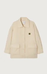 Chaqueta capitoneada color crema, de corte oversize, con cuello camisero, cierre frontal con botones a presión, bolsillos de parche y puños con abertura.