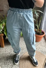Pantalón tipo babucha de denim celeste, con cintura elastizada y bolsillos cargo en los laterales.