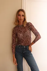 Remera de cuello alto confeccionada en microtul transparente con estampado animal print y mangas largas.