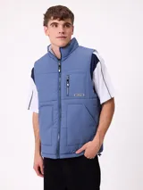 Chaleco reversible de nylon con diseño acolchado, cuello alto y cierre frontal. Cuenta con un bolsillo con cierre en el pecho y bolsillos laterales, además de una etiqueta con el logo de la marca.