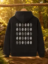 Hoodie oversize de color negro con capucha y estampado de hojas blancas en la espalda. Presenta un diseño de patrón repetitivo de hojas dispuestas en filas.