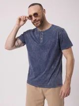 Remera color beige con cuello henley de tres botones y mangas cortas. Diseño estoneado.