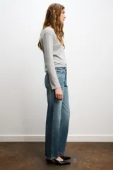 Jeans celeste de tiro alto, corte recto y largo, con cinco bolsillos y cierre frontal con cremallera y botón.