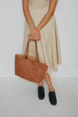 Cartera tote de cuero vacuno trenzado a mano, color bordó, de diseño espacioso con asas firmes.