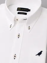 Camisa de algodón twill color blanco de corte clásico, con cuello button-down, bolsillo en el pecho con detalle bordado y botones en tono contrastante con costuras en cruz.