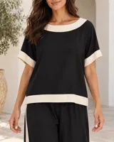 Blusa de manga corta color beige, con cuello redondo, dobladillo inferior y puños en color negro.