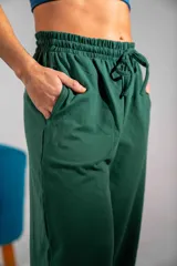 Pantalón de jogging verde oscuro con corte holgado, cintura elástica con cordón de ajuste y bolsillos laterales.