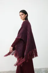 Ruana artesanal tejida en lana, con diseño de trama multicolor en tonos bordó, violeta y naranja, terminada con flecos en los extremos.
