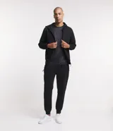 Pantalón de jogging negro, corte deportivo con puños ajustados en los tobillos y cintura con lazo. Confeccionado en algodón y poliéster con interior felpudo.