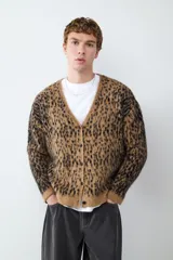 Cardigan de punto con estampado animal print, cuello en V y cierre frontal de botones. Presenta un diseño de textura suave y corte holgado.