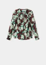 Blusa de gasa con estampado floral en tonos marrón, verde y crudo, escote en V con lazo ajustable y mangas largas con puños abotonados.