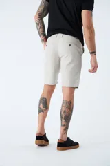 Bermuda tipo chino de corte clásico, confeccionada en una mezcla de lino y algodón. Presenta cierre de cremallera y botón, bolsillos laterales y traseros, y trabillas para cinturón.