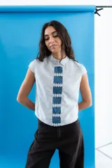 Top estampado de rayas con cuello alto y mangas cortas, con una franja central de denim adornada con apliques de encaje floral.