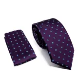 Conjunto de corbata y pañuelo de bolsillo color violeta con estampado de pequeñas figuras en forma de gota en color azul y blanco.