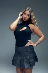 Minifalda tableada de cuero sintético con cintura ancha y cierre lateral con cordones.