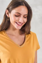 Remera de algodón color mostaza, de manga corta y escote en V con detalle metalizado.