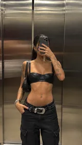 Top de cuero sintético negro con diseño estructurado tipo bustier y tirantes anchos.