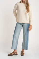 Sweater de tejido de punto color marrón, con cuello redondo, mangas largas y corte oversize. Presenta un detalle de costura decorativa en el frente y terminaciones en rib en cuello, puños y ruedo.