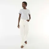 Pantalón de twill color beige, de corte ancho, con cintura asimétrica y cierre de botón descentrado.