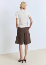 Jersey básico de tejido de punto fino color marfil, con cuello redondo y mangas cortas de corte entallado.