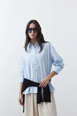 Camisa de manga larga con diseño de rayas verticales blancas y verdes, calce relajado, cuello clásico y botonadura frontal con botones perlados.