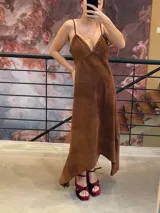 Vestido midi de antílope genuino color chocolate, con breteles finos, escote en V con detalle de pasamanería color cobre y falda de corte irregular.