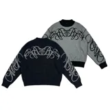 Sweater reversible de tejido de punto con diseño gráfico estilo tribal. Un lado presenta base negra con detalles en gris, mientras que el otro lado presenta base gris con detalles en negro. Posee cuello redondo, mangas largas y puños acanalados.