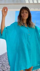 Túnica turquesa de lino con cuello mao, mangas cortas y ruedo desflecado.