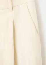 Pantalón largo de tiro medio, color beige, con diseño recto, trabillas para cinto y bolsillos laterales.