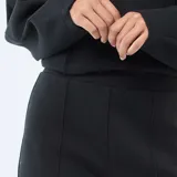 Pantalón de corte flare y tiro medio, confeccionado en felpa ligera de color negro. Presenta una costura vertical central en el frente de cada pierna y un diseño de calce fluido.