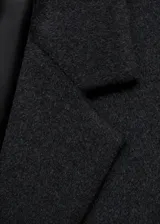 Abrigo de paño con mezcla de lana, diseño recto de doble botonadura, cuello con solapas de muesca, manga larga y dos bolsillos laterales con solapa.
