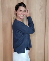 Sweater de tejido de punto color turquesa, con cuello en V y mangas largas de corte holgado.