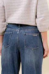 Jean wide leg de tiro alto con costura frontal decorativa, bolsillos delanteros con remaches y bolsillos traseros amplios. Presenta un interior afelpado para mayor abrigo.