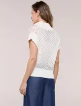 Buzo de punto color marfil, confeccionado en algodón calado con cuello alto acanalado y medio cierre metálico dorado. Presenta mangas cortas estilo japonesa con puños anchos y un zócalo acanalado en el ruedo.