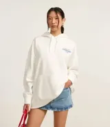 Buzo overtop con capucha confeccionado en algodón más sostenible, con forro de polar y bolsillo canguro. Presenta estampa en lettering en frente y espalda, y bordado toallado.