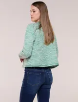 Chaqueta de tweed liviano en color verde, con escote redondo, frente abierto y bolsillos simulados con detalles de pasamanería. Cuenta con mangas largas de corte recto.