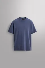 Camiseta de corte regular fit confeccionada en algodón, con cuello redondo y mangas cortas, presentando un acabado de color azul con efecto lavado.