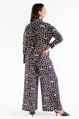 Camisa de manga larga de tejido fluido, color negro con estampado de círculos y pequeños peces en tonos claros. Cuenta con cuello camisero, cierre frontal con botones y puños ajustados.