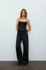 Top negro de escote en pico con tirantes finos ajustables, diseño entallado y cierre lateral con cremallera.