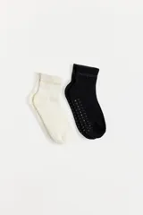 Pack de dos pares de medias cortas marca Caro Cuore, una en color blanco y otra en color negro. Presentan diseño acanalado en la caña con el nombre de la marca y suela antideslizante con puntos de silicona.