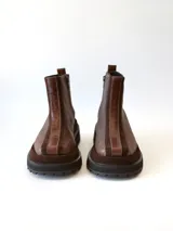 Bota corta de cuero en tonos chocolate, con diseño de paneles texturizados y suela track robusta de goma.