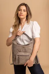 Cartera mochila color tostado, de cuero sintético, con compartimento principal amplio y bolsillos frontales con cierre. Tiene correas ajustables y asa superior para llevar al hombro o como mochila.