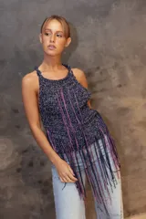 Top tejido a crochet en tonos azul y plateado, con diseño de cuello redondo y flecos largos en la parte frontal en colores azul y fucsia.