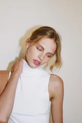 Top blanco de cuello alto y manga sisa, confeccionado con mezcla de poliamida, de corte ajustado al cuerpo y bajo recto.